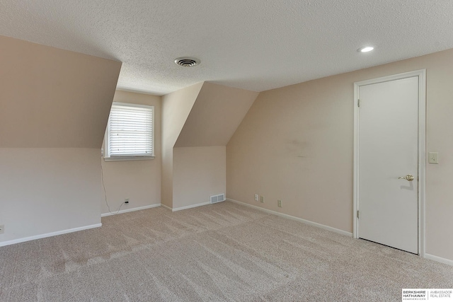 bonus room featuring visible vents, baseboards, a textured ceiling, and carpet flooring