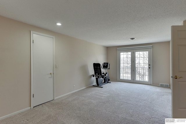 unfurnished room with visible vents, a textured ceiling, baseboards, and carpet floors