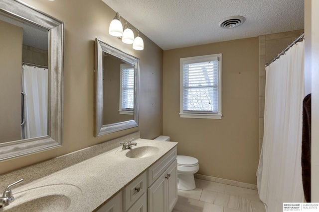 full bath featuring a sink, visible vents, a textured ceiling, and double vanity