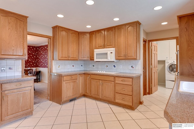 kitchen with a sink, white appliances, washer / clothes dryer, and light countertops