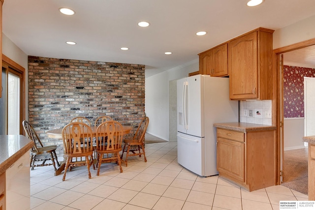 kitchen with light tile patterned floors, white refrigerator with ice dispenser, ornamental molding, and recessed lighting