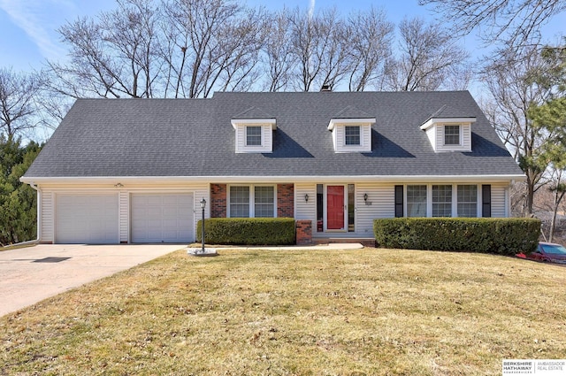 new england style home featuring brick siding, a front lawn, roof with shingles, a garage, and driveway