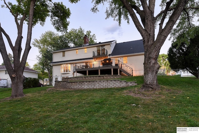 rear view of property with stairway, a yard, and a deck