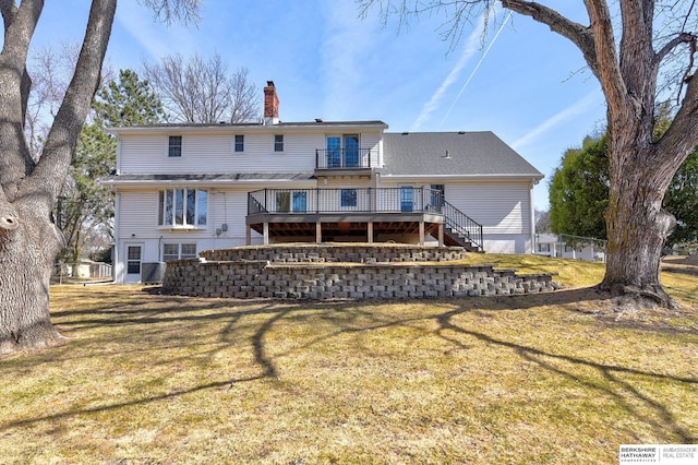 rear view of house featuring stairway, a lawn, a chimney, and a deck