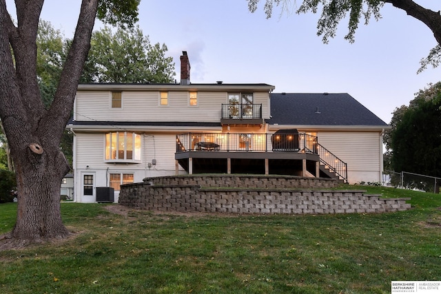 back of house with a chimney, stairway, a wooden deck, and a yard