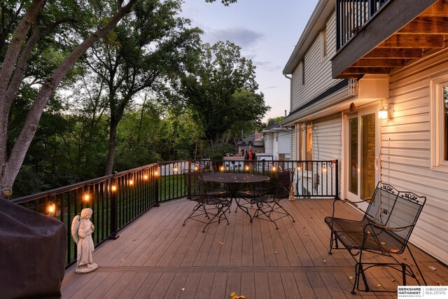 wooden deck with outdoor dining space and a grill