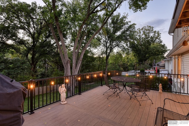 wooden terrace with outdoor dining area and area for grilling