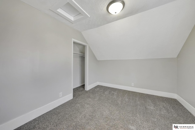 bonus room with baseboards, a textured ceiling, lofted ceiling, and carpet floors