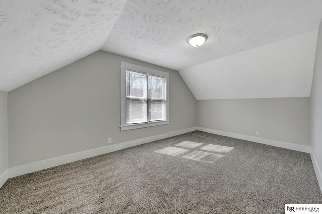 bonus room featuring carpet flooring, a textured ceiling, lofted ceiling, and baseboards