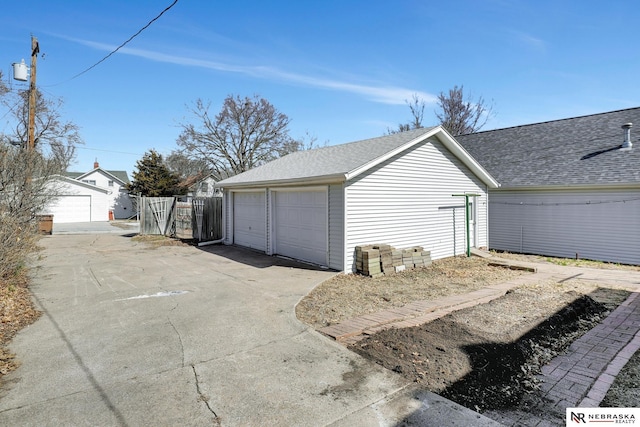 detached garage featuring fence