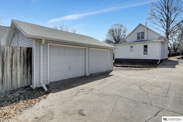 detached garage featuring fence