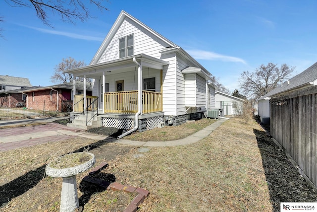 view of front of house with cooling unit, fence, and covered porch