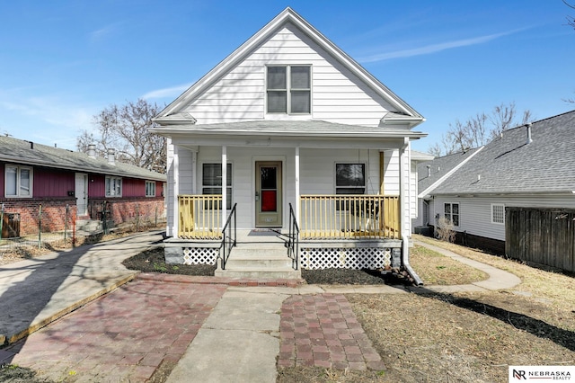 view of front facade featuring a porch and fence