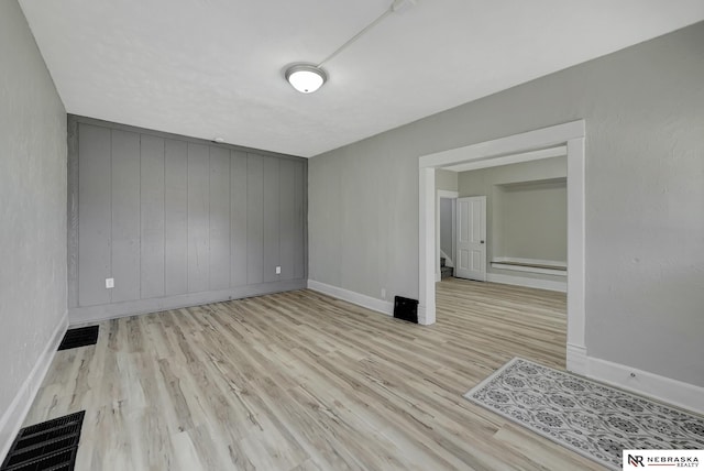 spare room featuring visible vents, stairway, and wood finished floors