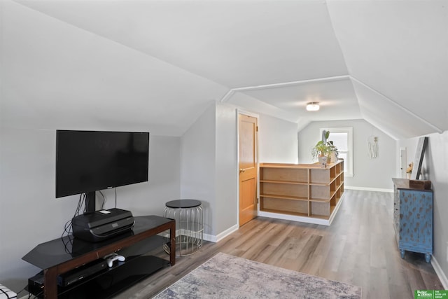 bonus room featuring baseboards, lofted ceiling, and wood finished floors