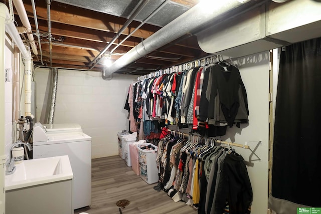 unfinished basement with a sink, light wood-style flooring, and washing machine and dryer