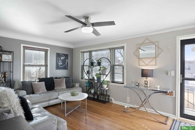 living area with ceiling fan, baseboards, wood finished floors, and crown molding