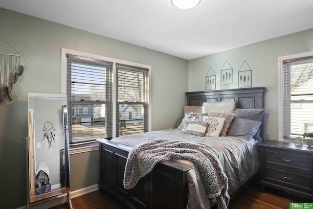 bedroom with dark wood-type flooring and baseboards