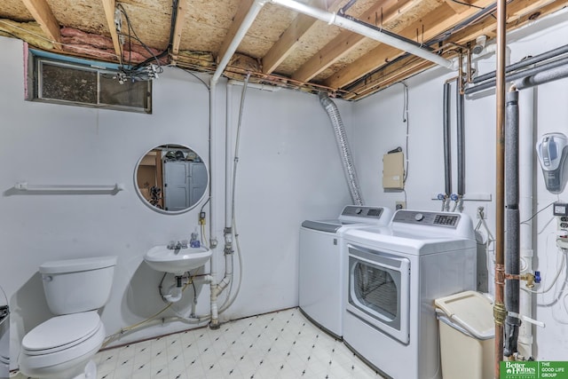 clothes washing area featuring light floors, laundry area, and washer and clothes dryer