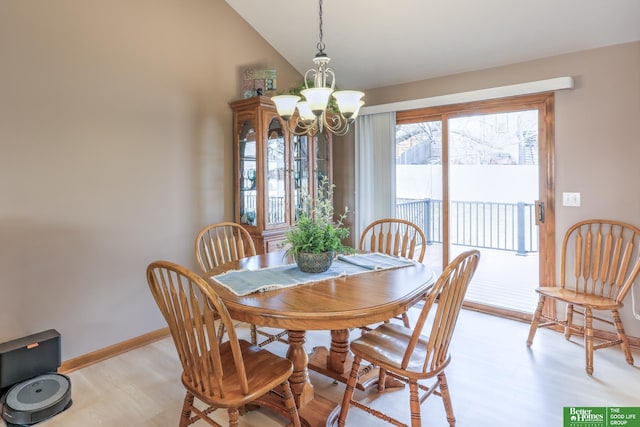 dining area featuring lofted ceiling, light wood-style flooring, baseboards, and a chandelier