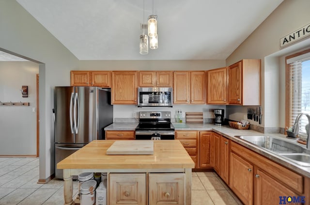 kitchen with lofted ceiling, light tile patterned flooring, a sink, butcher block countertops, and stainless steel appliances