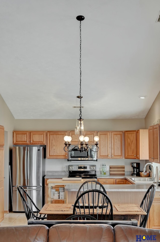 kitchen with a kitchen island, stainless steel appliances, light countertops, and a sink