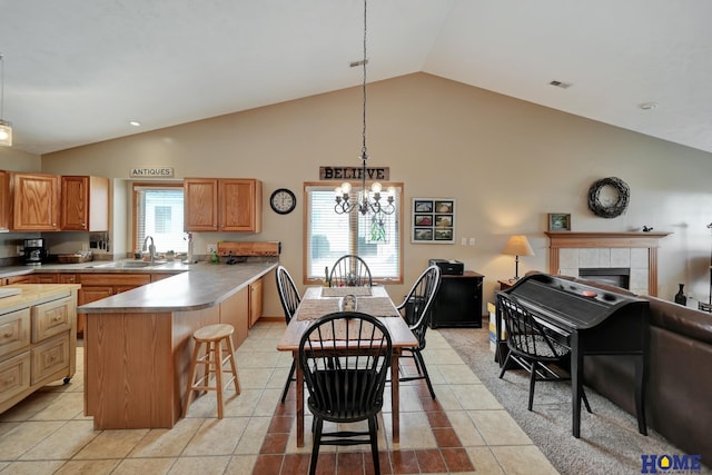 kitchen with a breakfast bar area, a peninsula, a sink, open floor plan, and a wealth of natural light