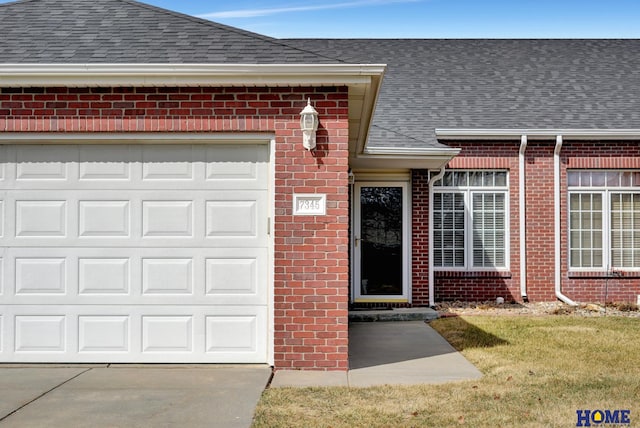 doorway to property with brick siding, roof with shingles, and concrete driveway