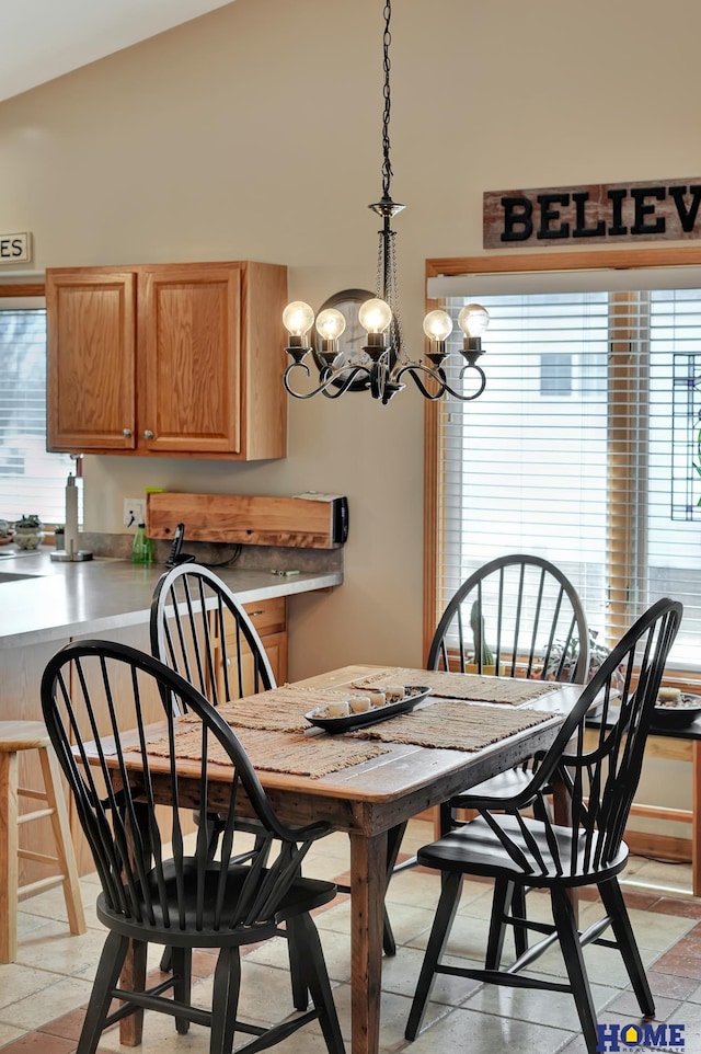 dining space with an inviting chandelier and vaulted ceiling