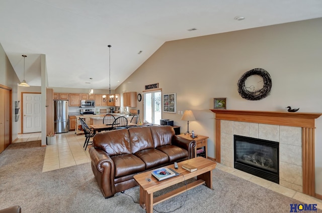 living area featuring light tile patterned floors, visible vents, high vaulted ceiling, a fireplace, and light carpet