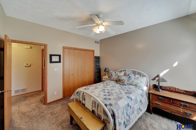 carpeted bedroom featuring a ceiling fan, visible vents, a closet, and baseboards