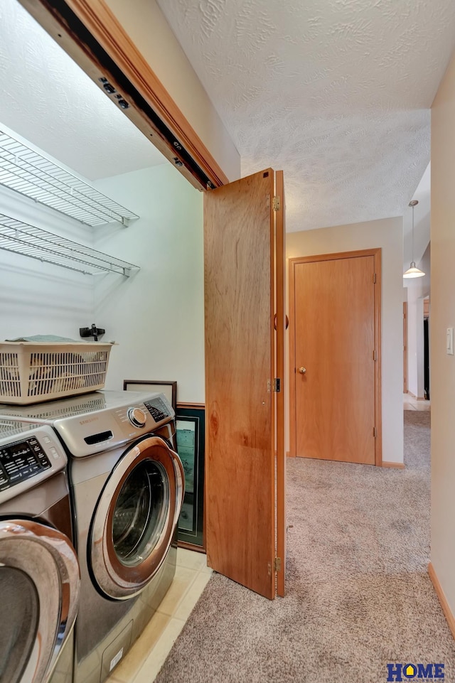 laundry room featuring washing machine and clothes dryer, baseboards, carpet floors, laundry area, and a textured ceiling