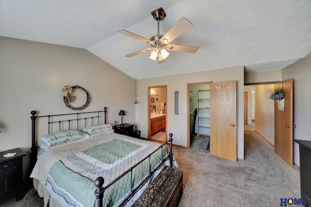 carpeted bedroom with baseboards, ceiling fan, vaulted ceiling, a spacious closet, and connected bathroom