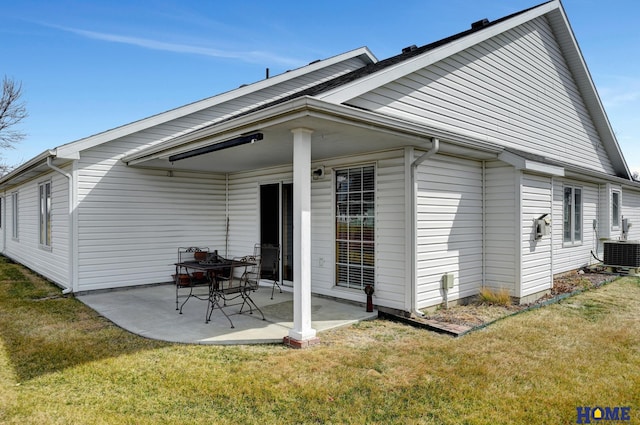 rear view of house with central air condition unit, a patio area, and a lawn