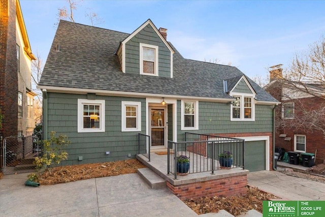 view of front facade featuring a garage, a chimney, roof with shingles, and driveway