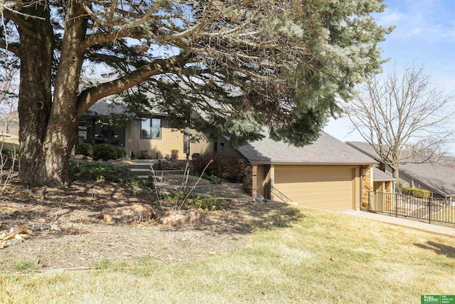 obstructed view of property featuring a front yard, fence, driveway, a garage, and brick siding