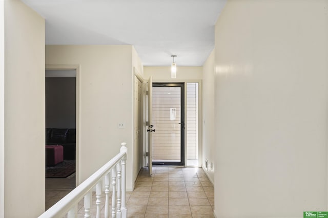 interior space with light tile patterned floors and an upstairs landing