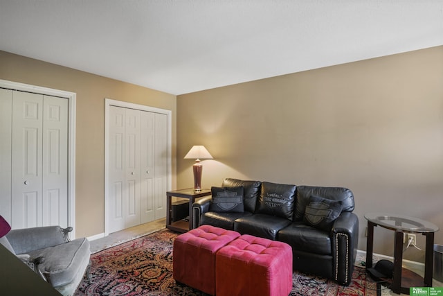 carpeted living area with baseboards