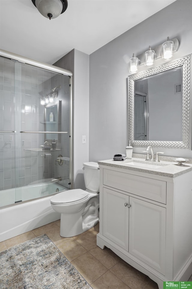 full bathroom with tile patterned floors, visible vents, toilet, bath / shower combo with glass door, and vanity