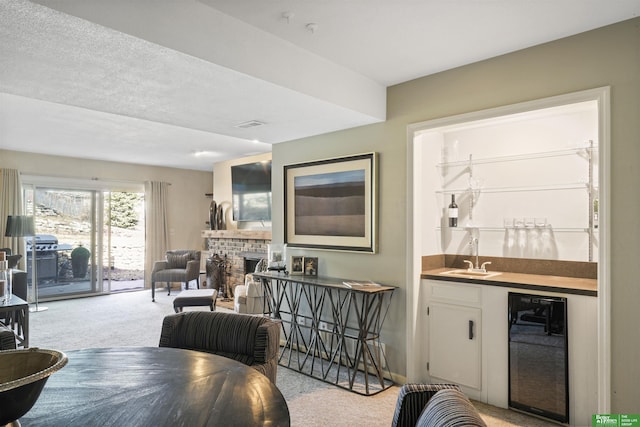 dining space featuring wet bar, light colored carpet, beverage cooler, and a fireplace