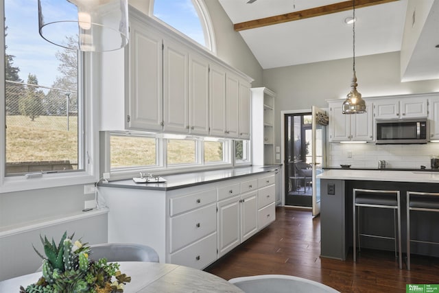 kitchen with stainless steel microwave, white cabinetry, and dark wood-style flooring