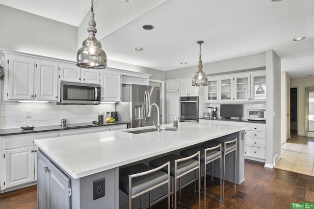 kitchen featuring dark wood-type flooring, white cabinets, tasteful backsplash, and stainless steel appliances