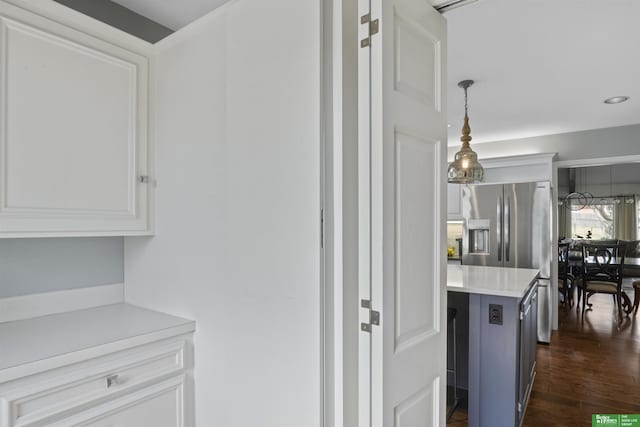 kitchen with decorative light fixtures, white cabinets, stainless steel fridge with ice dispenser, light countertops, and dark wood-style flooring