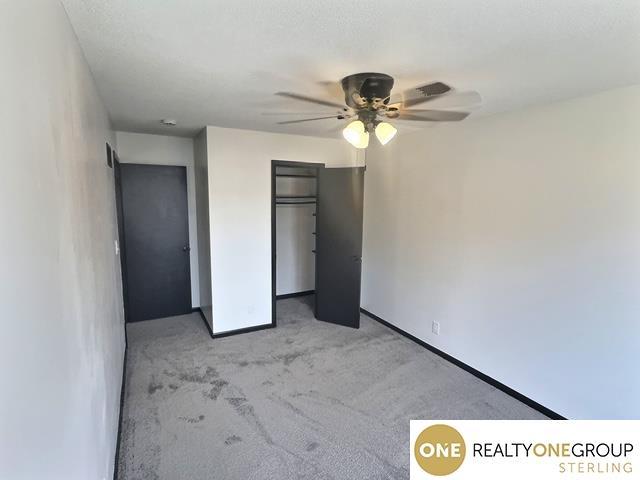 unfurnished bedroom with a closet, light carpet, and a ceiling fan