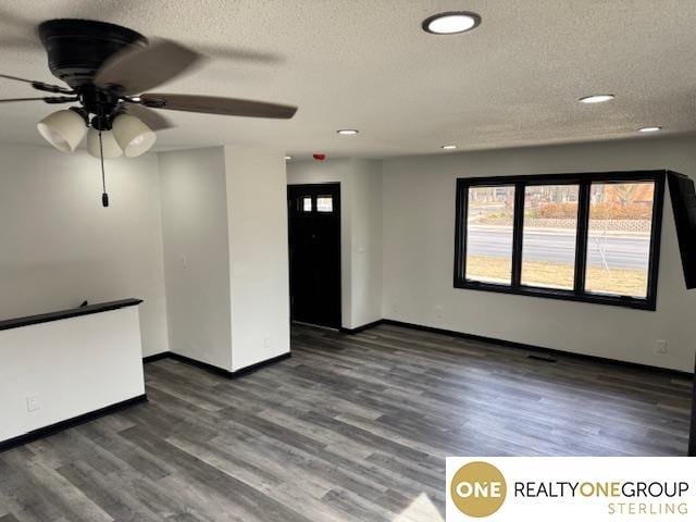 unfurnished living room with recessed lighting, baseboards, a textured ceiling, and wood finished floors