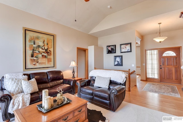 living area with light wood finished floors and lofted ceiling