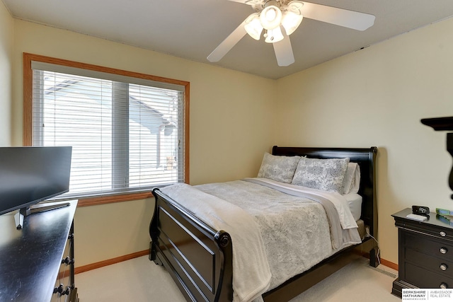 bedroom featuring light colored carpet, a ceiling fan, and baseboards