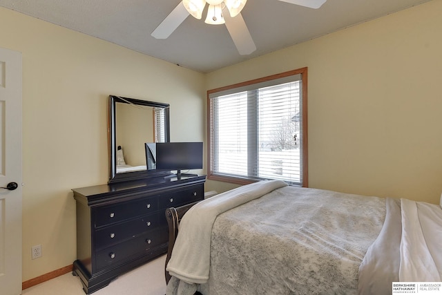 bedroom with light colored carpet, baseboards, and ceiling fan