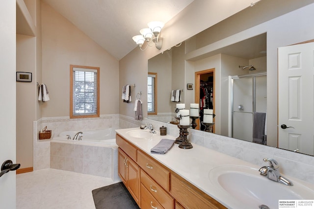 bathroom featuring a bath, vaulted ceiling, a stall shower, and a sink