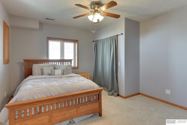 bedroom with visible vents, baseboards, light colored carpet, and a textured ceiling